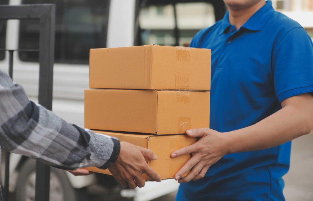 Asian delivery express courier young man use giving boxes to wom Zustellung: Expresskurier übergibt Kartons an Kundin
